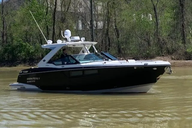 Slide: The Image of 2017 Monterey 378 SE boat cruising on a calm river with lush green trees. - 0