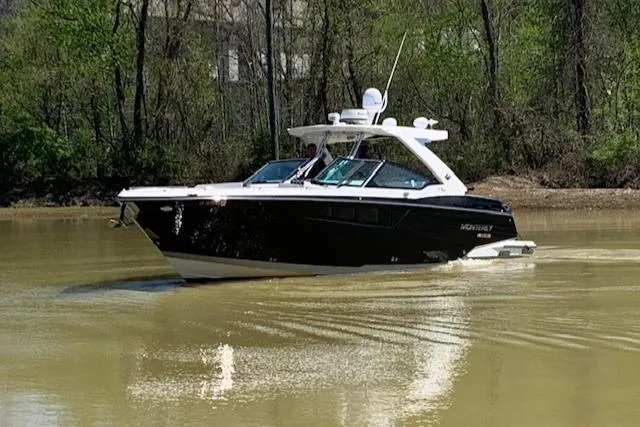Slide: The Image of 2017 Monterey 378 SE boat cruising on a calm river with lush greenery. - 1