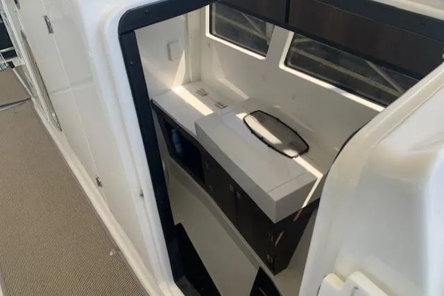 Slide: The Image of 2017 Monterey 378 SE boat interior with compact kitchenette and windows. - 29