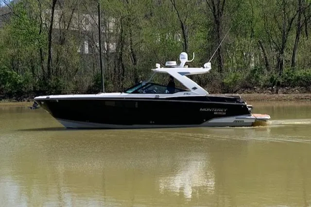 Slide: The Image of 2017 Monterey 378 SE boat cruising on a calm river with lush green trees. - 3
