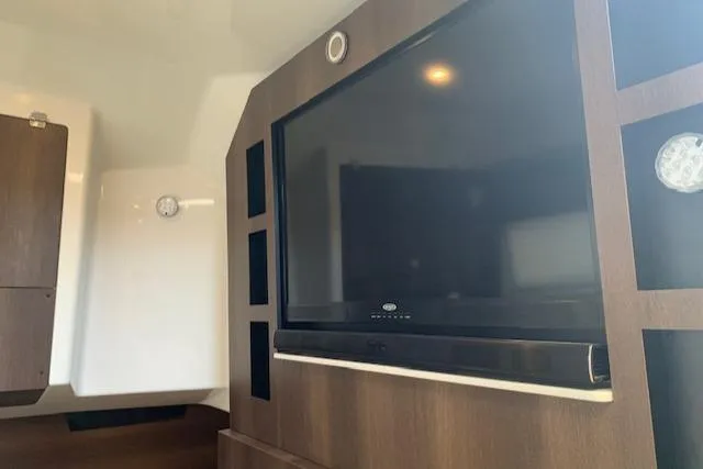 Slide: The Image of Interior of 2017 Monterey 378 SE boat featuring a mounted flat-screen TV. - 36