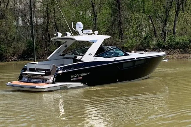 Slide: The Image of 2017 Monterey 378 SE boat on calm water, surrounded by lush greenery. - 4