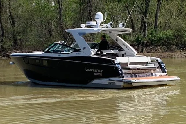 Slide: The Image of 2017 Monterey 378 SE boat cruising on a calm river with lush green trees. - 5