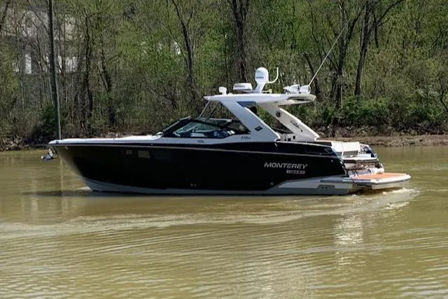 Slide: The Image of 2017 Monterey 378 SE boat cruising on a calm river with lush green trees. - 6