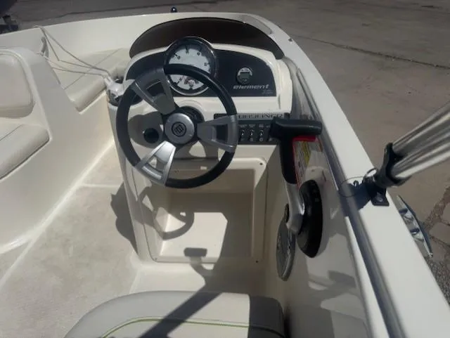 Slide: The Image of 2003 Bayliner Element E18 boat cockpit with steering wheel and dashboard controls. - 4