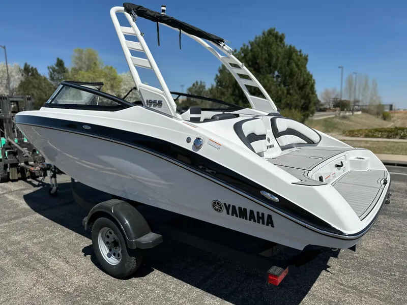 Slide: The Image of 2025 Yamaha Boats 195S on trailer, sleek white design, outdoor setting. - 2