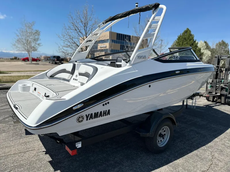Slide: The Image of 2025 Yamaha Boats 195S on trailer, sleek design, white exterior, parked outdoors. - 4