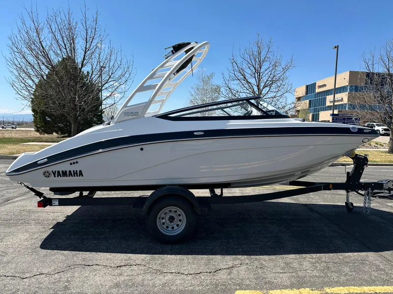 Slide: The Image of 2025 Yamaha Boats 195S on trailer, parked outdoors, clear sky background. - 5