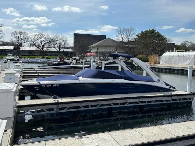 The Image of 2020 Regal LS6 Surf boat docked at a marina under a clear blue sky. - 0