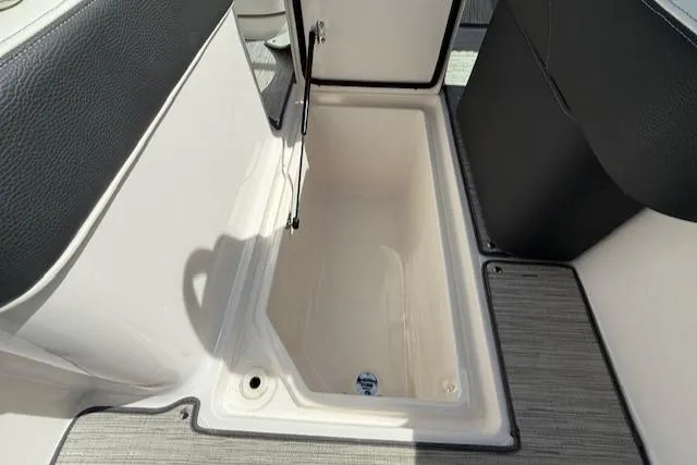 Slide: The Image of 2020 Regal LS6 Surf boat with spacious white seating at a marina. - 22