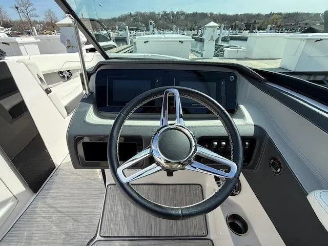 Slide: The Image of 2020 Regal LS6 Surf boat interior with modern dashboard and seating at a marina. - 8