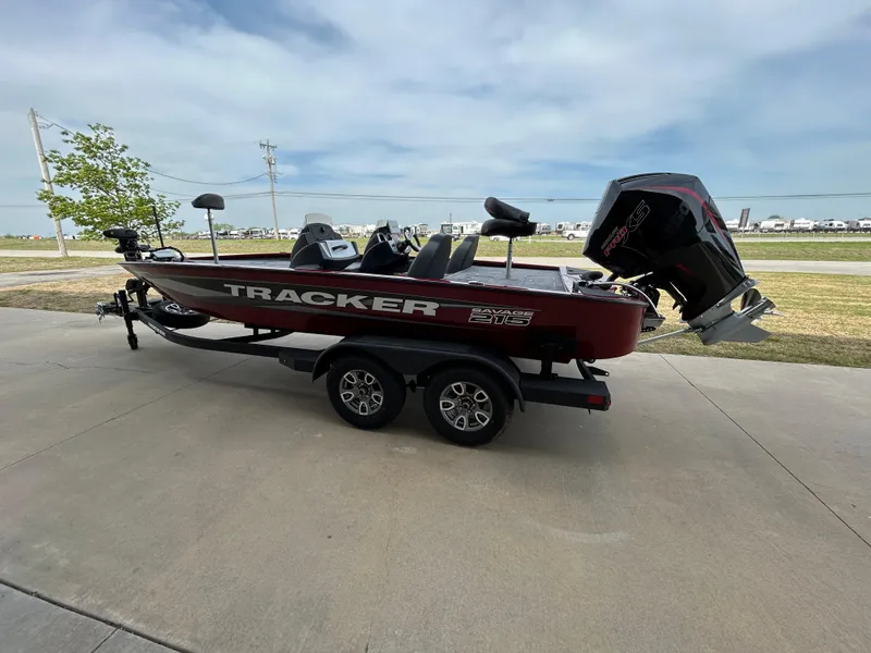 Slide: The Image of 2025 Tracker Savage 215 boat on trailer, parked outdoors, side view. - 2