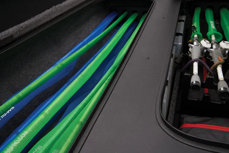 Slide: The Image of Storage compartment of 2025 Tracker Savage 215 with organized fishing rods and equipment. - 35