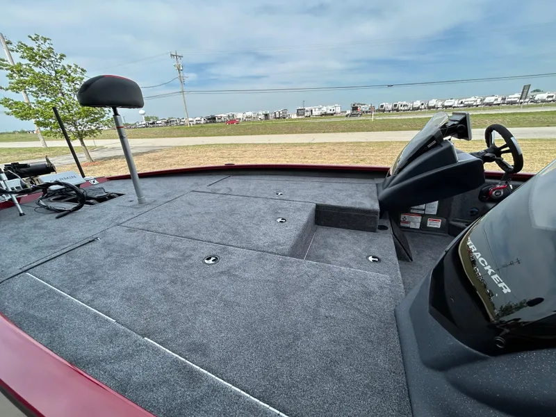 Slide: The Image of 2025 Tracker Savage 215 boat interior with steering wheel and seating, parked outdoors. - 6