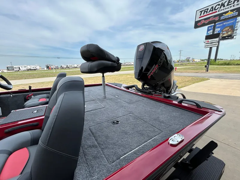 Slide: The Image of 2025 Tracker Savage 215 boat with motor, red and gray interior, outdoor dealership display. - 7