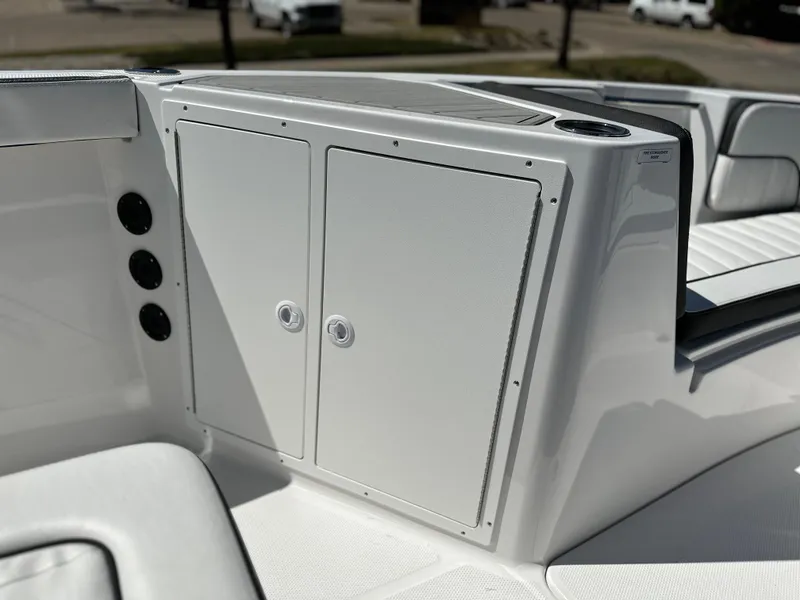 Slide: The Image of 2025 Yamaha Boats 222 FSH Sport interior storage compartment with sleek white design. - 15