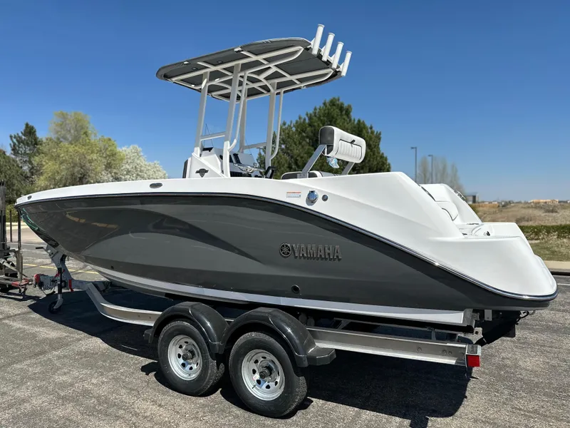 Slide: The Image of 2025 Yamaha Boats 222 FSH Sport on trailer, sleek design, outdoor setting. - 2