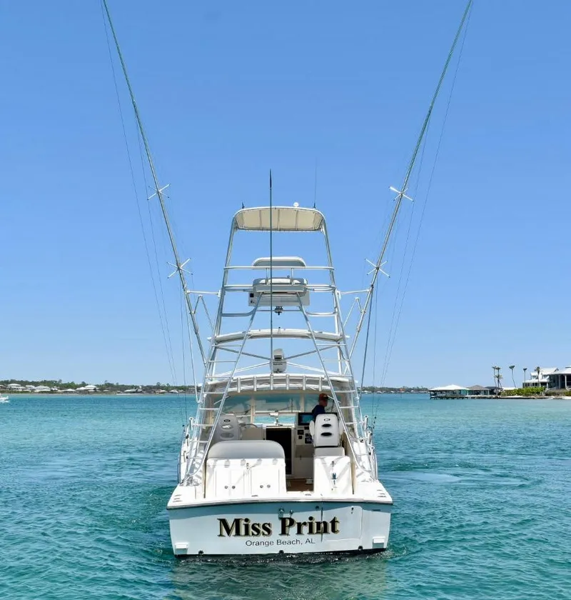 Slide: The Image of 2006 Carolina Classic 32 boat on clear blue water, rear view. - 5
