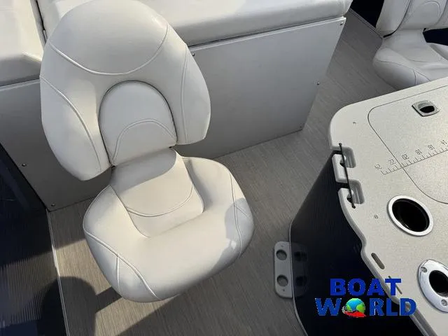 Slide: The Image of 2017 Bennington 21SSX Pontoon boat interior with white seating and table, Boat World logo visible. - 34
