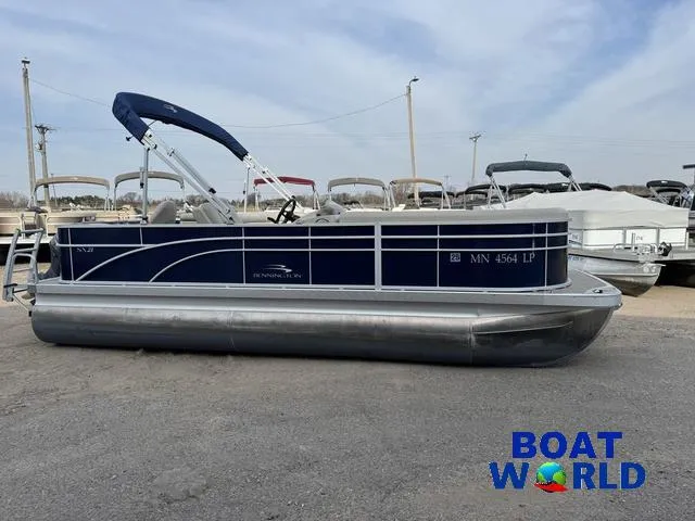 Slide: The Image of 2017 Bennington 21SSX Pontoon boat with blue canopy, displayed at Boat World dealership. - 43