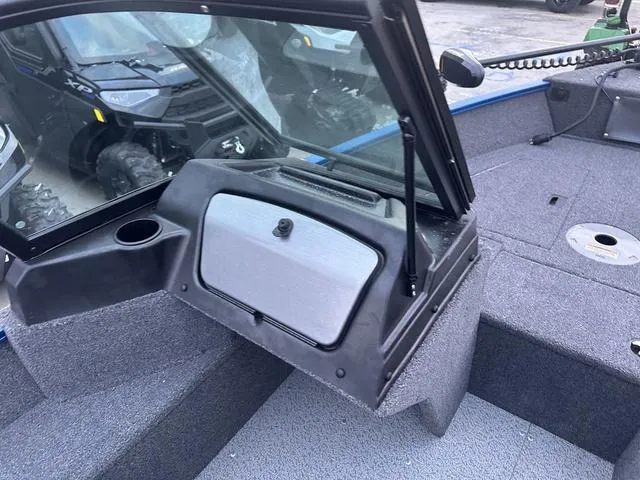 Slide: The Image of 2024 Lund 1650 Angler Sport boat interior with windshield and storage compartment. - 11