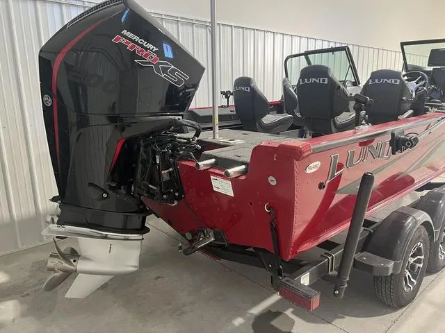 Slide: The Image of 2024 Lund 2025 Impact XS Sport boat with Mercury Pro XS engine in a showroom. - 10