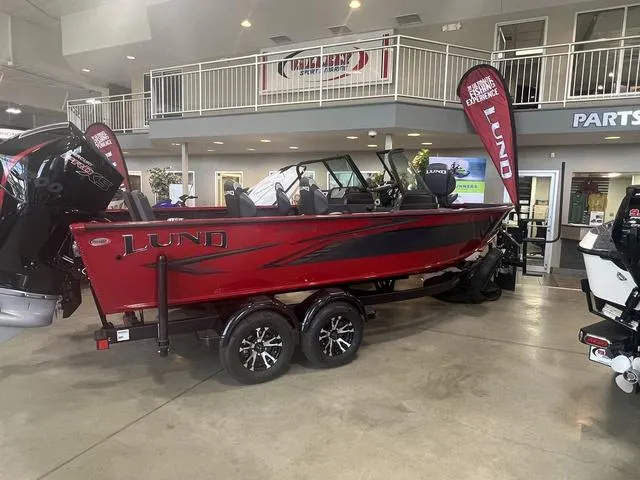 Slide: The Image of 2024 Lund 2025 Impact XS Sport boat displayed in showroom, red and black design. - 11