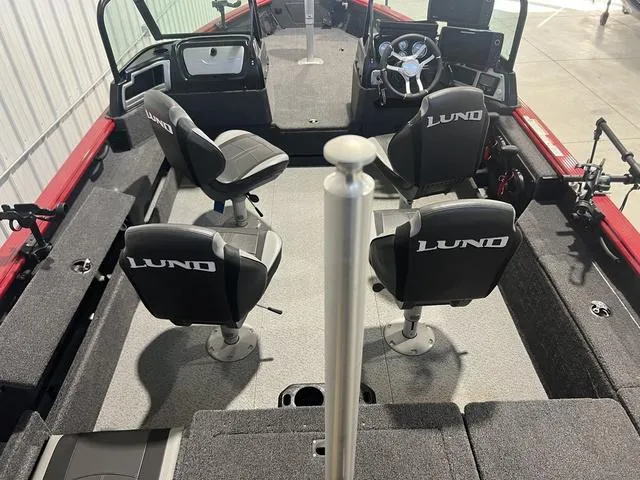 Slide: The Image of 2024 Lund 2025 Impact XS Sport boat interior with seating and steering wheel. - 12