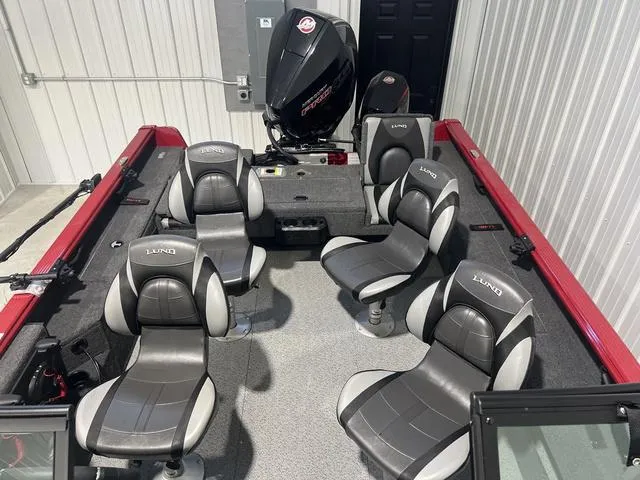 Slide: The Image of 2024 Lund 2025 Impact XS Sport boat interior with five seats and motor in a garage. - 18