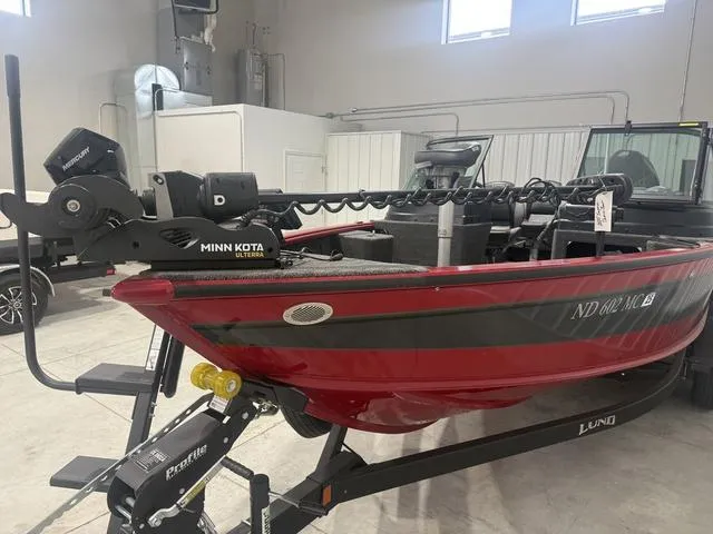 Slide: The Image of 2024 Lund 2025 Impact XS Sport boat in a showroom, featuring Minn Kota trolling motor. - 3