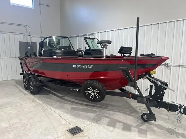 Slide: The Image of 2024 Lund 2025 Impact XS Sport boat in a garage, red and black design, on a trailer. - 8