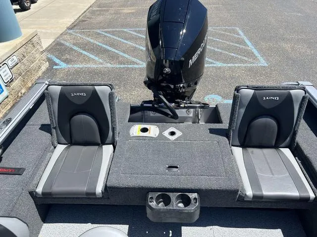 Slide: The Image of 2024 Lund 2025 Impact XS Sport boat interior with two seats and Mercury outboard motor. - 10