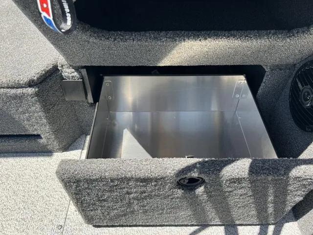 Slide: The Image of 2024 Lund 2025 Impact XS Sport boat storage compartment, open and empty, with carpeted interior. - 11