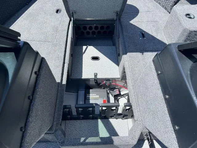 Slide: The Image of 2024 Lund 2025 Impact XS Sport boat interior with storage compartments and battery system. - 14