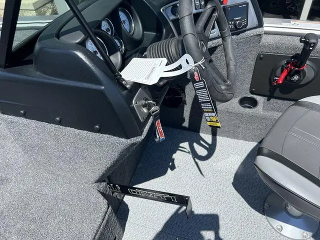 Slide: The Image of 2024 Lund 2025 Impact XS Sport boat interior with steering wheel and dashboard controls. - 16