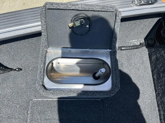 Slide: The Image of 2024 Lund 2025 Impact XS Sport boat livewell compartment, open lid, gray interior. - 18