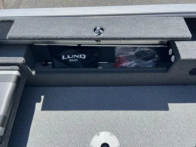 Slide: The Image of 2024 Lund 2025 Impact XS Sport boat storage compartment with Lund Boats bag and accessories. - 25