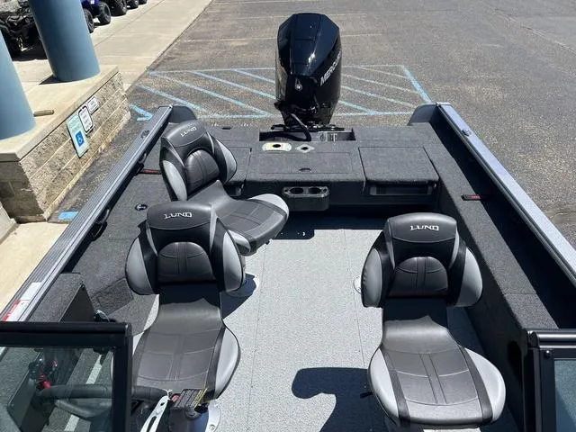 Slide: The Image of 2024 Lund 2025 Impact XS Sport boat interior with four seats and motor. - 5