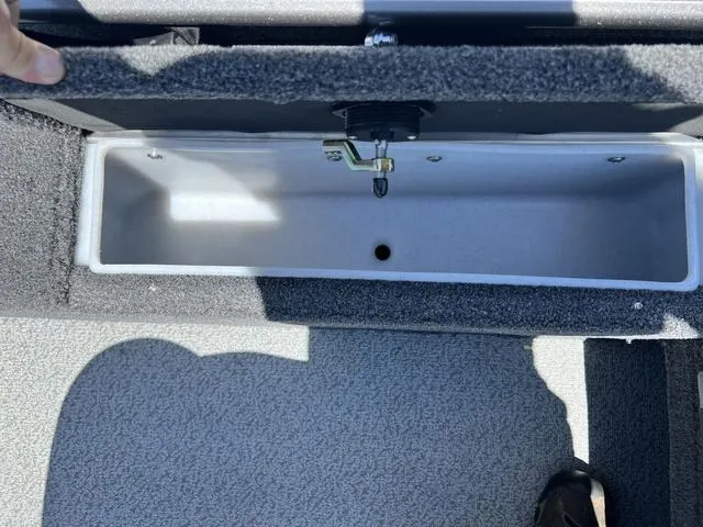 Slide: The Image of 2024 Lund 2025 Impact XS Sport boat storage compartment, open and empty. - 9