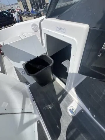 Slide: The Image of 2024 Yamaha AR190 boat interior with storage compartment and trash bin. - 13