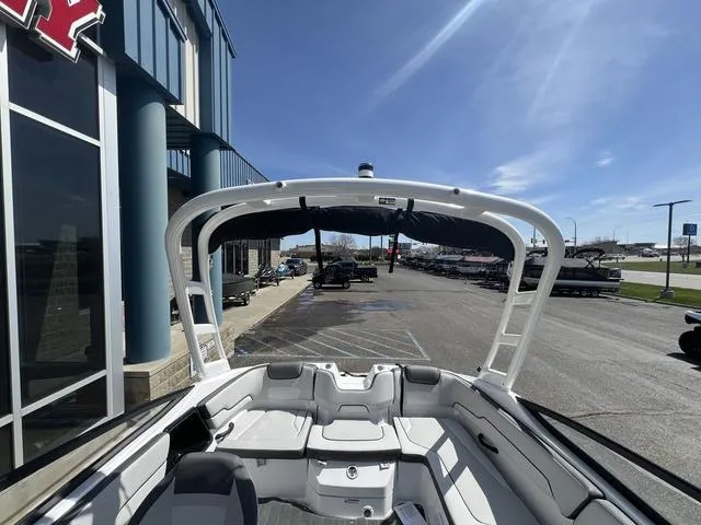 Slide: The Image of 2024 Yamaha Boats AR190, sleek interior, docked at marina under clear blue sky. - 17