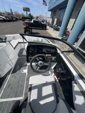 Slide: The Image of 2024 Yamaha Boats AR190 cockpit with steering wheel and dashboard, parked outside dealership. - 20