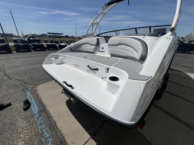 Slide: The Image of 2024 Yamaha Boats AR190, rear view, sleek design, white exterior, parked outdoors. - 6