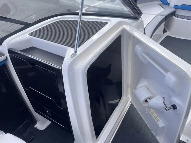 Slide: The Image of 2016 Yamaha Boats 242X E-Series interior with open storage compartment and seating area. - 21