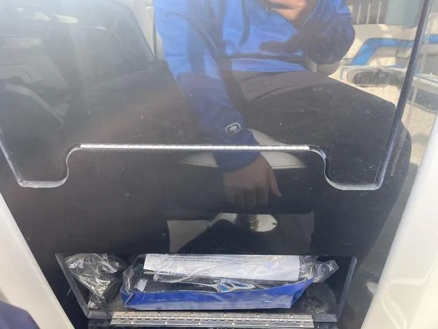 Slide: The Image of 2016 Yamaha Boats 242X E-Series interior with reflection of person in blue jacket. - 23