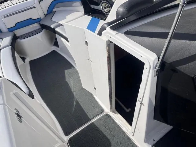 Slide: The Image of 2016 Yamaha Boats 242X E-Series interior with open storage compartment and seating. - 24