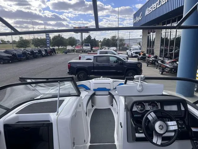 Slide: The Image of 2016 Yamaha Boats 242X E-Series interior view at dealership, showcasing dashboard and seating. - 32