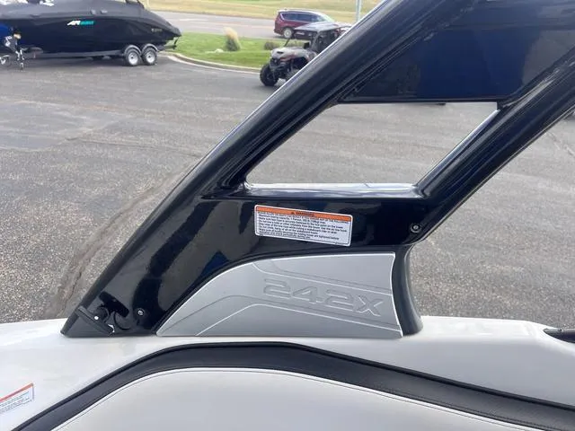 Slide: The Image of 2016 Yamaha Boats 242X E-Series, black and gray detailing, parked outdoors. - 35