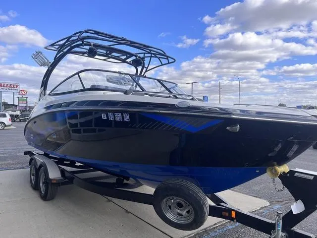 Slide: The Image of 2016 Yamaha Boats 242X E-Series on trailer, parked outdoors under a cloudy sky. - 4