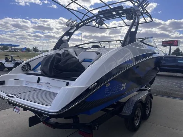 Slide: The Image of 2016 Yamaha Boats 242X E-Series on trailer, sleek design, outdoor setting, partly cloudy sky. - 5